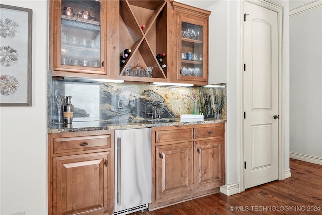 bar featuring sink, stainless steel fridge, light stone countertops, tasteful backsplash, and dark hardwood / wood-style flooring