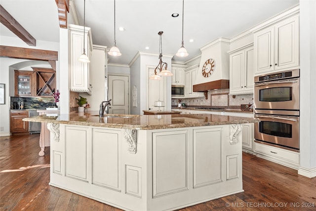 kitchen with light stone countertops, sink, stainless steel appliances, dark hardwood / wood-style flooring, and pendant lighting