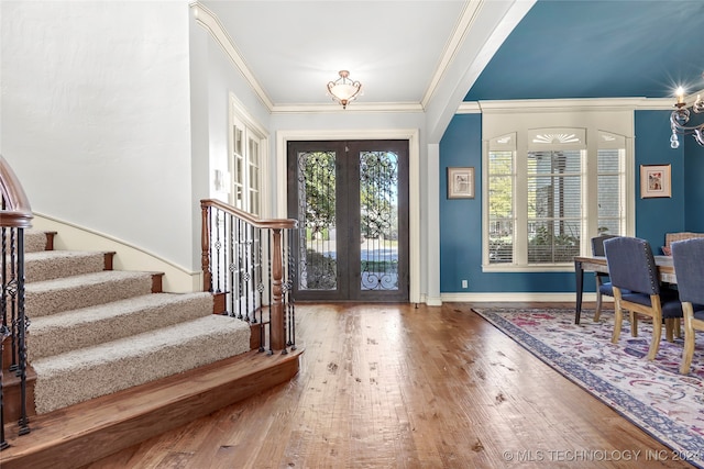 entryway with hardwood / wood-style floors, french doors, and ornamental molding