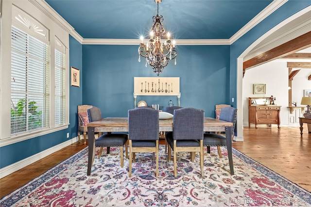 dining room with wood-type flooring, crown molding, a wealth of natural light, and a chandelier