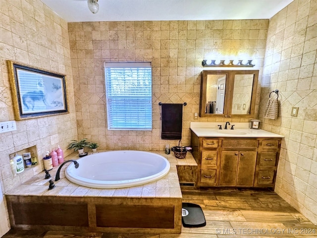 bathroom with hardwood / wood-style floors, vanity, and tile walls