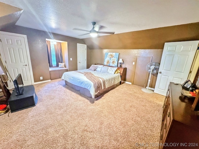 carpeted bedroom with a textured ceiling, ceiling fan, and lofted ceiling