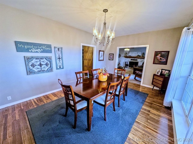 dining space featuring dark wood-type flooring and an inviting chandelier