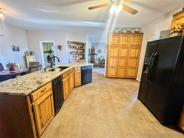 kitchen featuring ceiling fan, sink, black appliances, washer / clothes dryer, and an island with sink