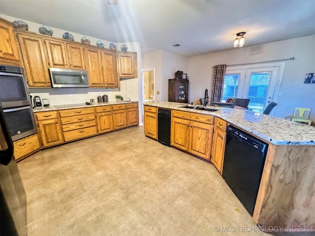 kitchen featuring black appliances, a center island, sink, and light carpet