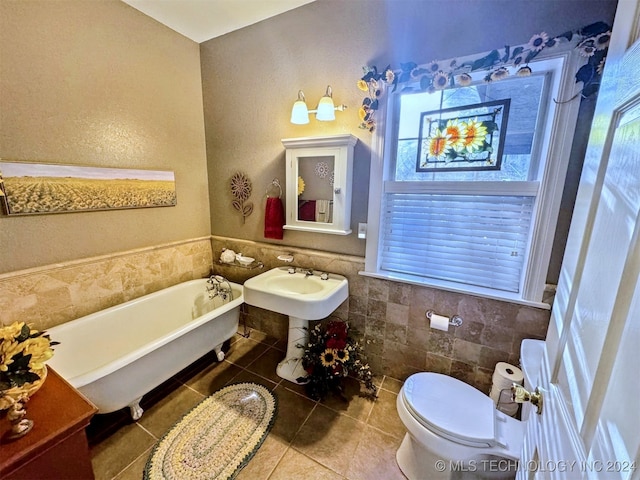 bathroom with tile patterned flooring, a healthy amount of sunlight, tile walls, and toilet