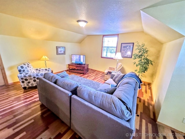 living room featuring wood-type flooring, a textured ceiling, and vaulted ceiling