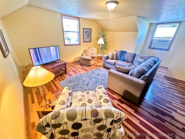 living room with hardwood / wood-style floors, vaulted ceiling, plenty of natural light, and cooling unit