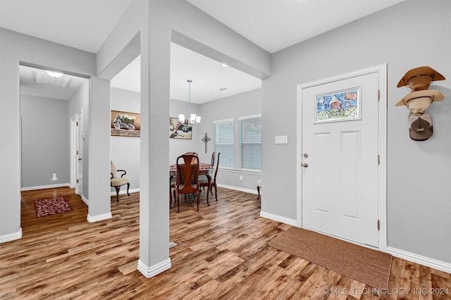 foyer with light hardwood / wood-style flooring and an inviting chandelier