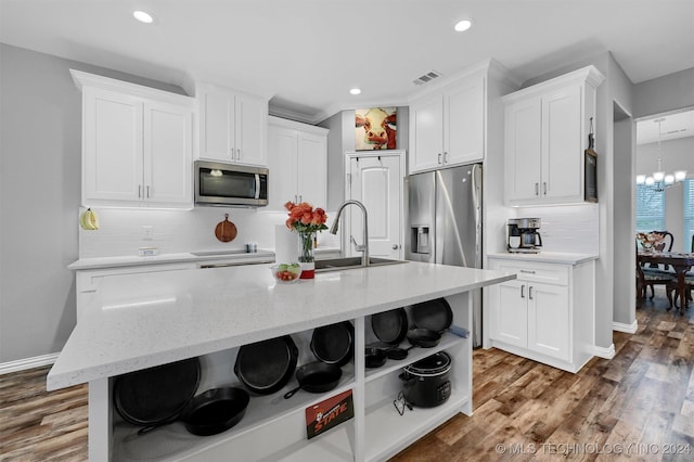 kitchen featuring dark hardwood / wood-style floors, white cabinetry, stainless steel appliances, and an island with sink