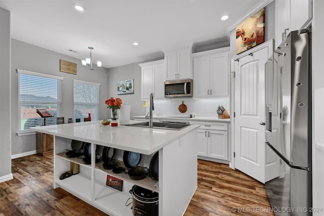 kitchen featuring white cabinetry, a center island with sink, and appliances with stainless steel finishes