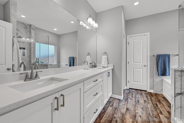 bathroom featuring hardwood / wood-style flooring, vanity, and plus walk in shower