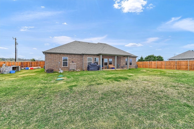 back of property featuring a patio area and a yard