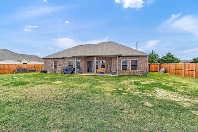 rear view of property featuring a patio area and a lawn