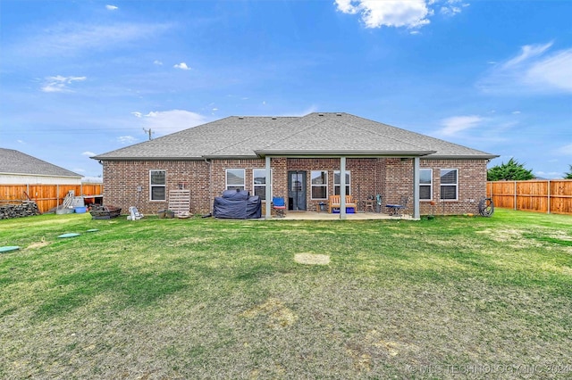 rear view of house featuring a lawn and a patio area