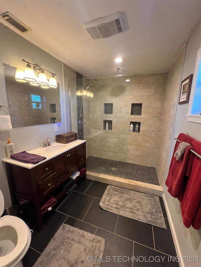 bathroom with tile patterned floors, vanity, and tiled shower