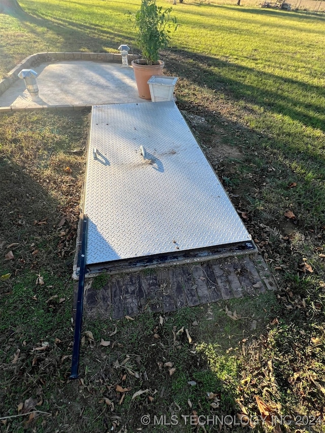 entry to storm shelter featuring a yard