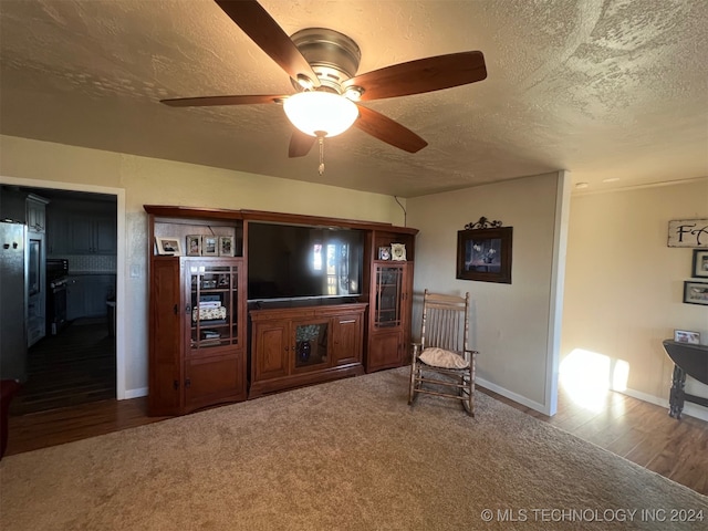 unfurnished living room featuring hardwood / wood-style floors, ceiling fan, and a textured ceiling