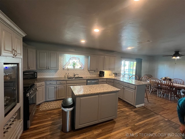 kitchen featuring dark hardwood / wood-style flooring, sink, a kitchen island, and black appliances