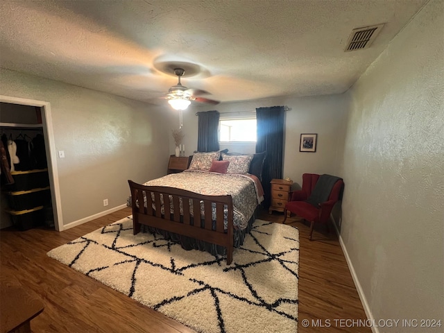 bedroom featuring ceiling fan, wood-type flooring, a textured ceiling, and a closet