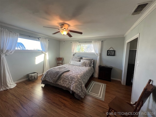 bedroom with ceiling fan, crown molding, and dark wood-type flooring