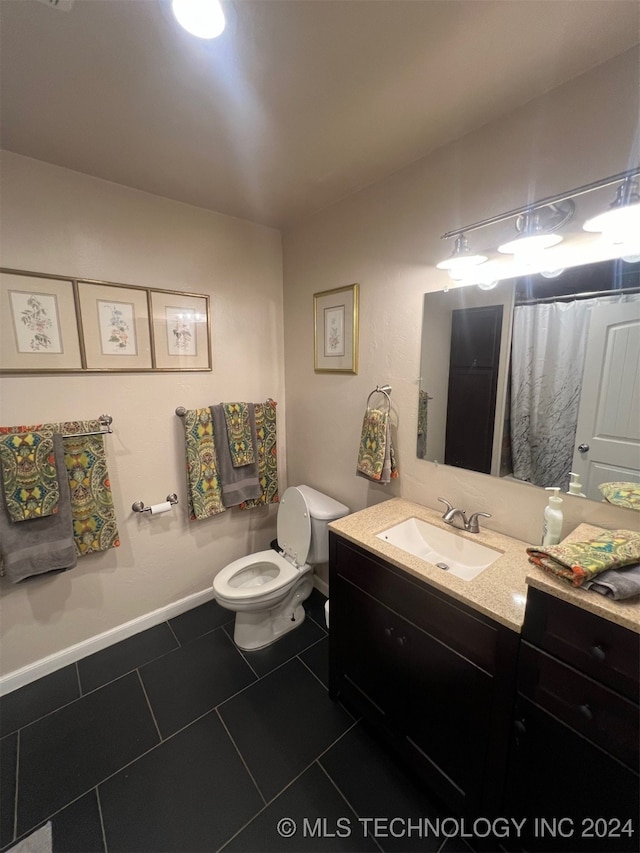 bathroom featuring tile patterned flooring, vanity, and toilet