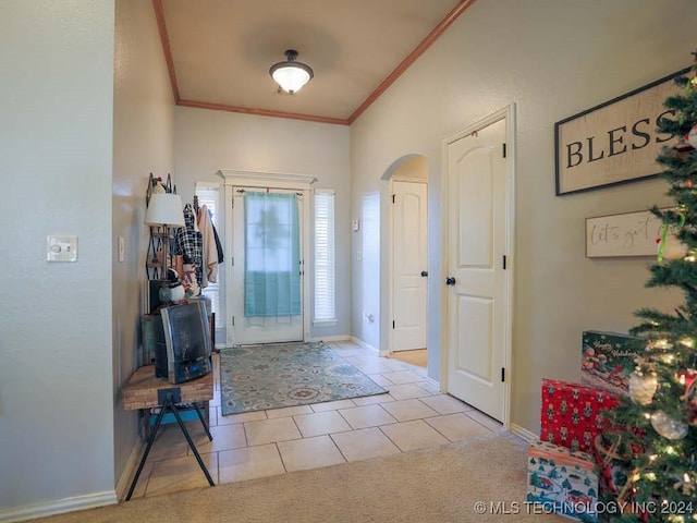 tiled foyer featuring crown molding