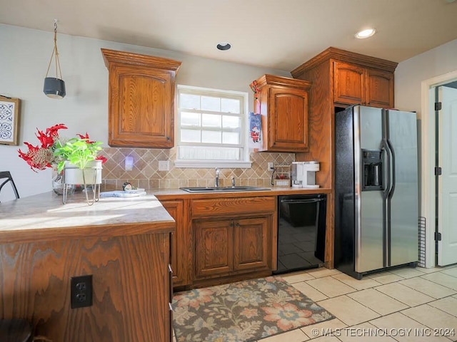 kitchen with sink, black dishwasher, stainless steel refrigerator with ice dispenser, decorative light fixtures, and light tile patterned floors