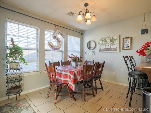 tiled dining room featuring a chandelier and plenty of natural light