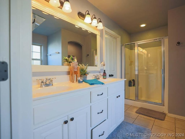 bathroom with tile patterned flooring, vanity, and a shower with shower door