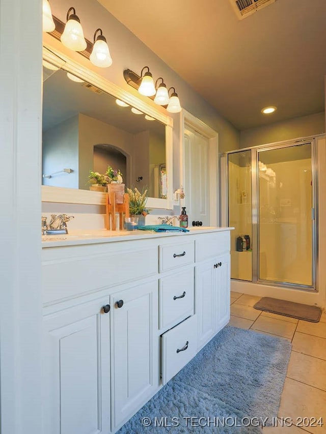 bathroom featuring tile patterned flooring, vanity, and a shower with door