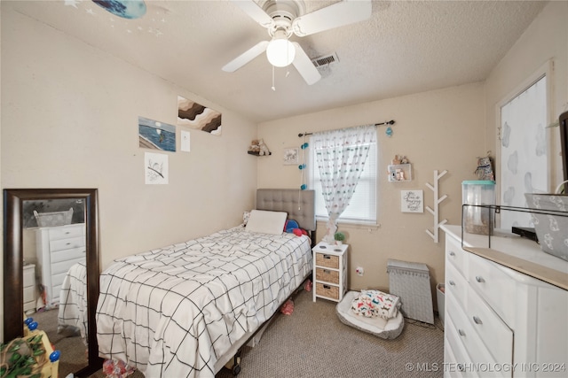 bedroom featuring ceiling fan, carpet, and a textured ceiling