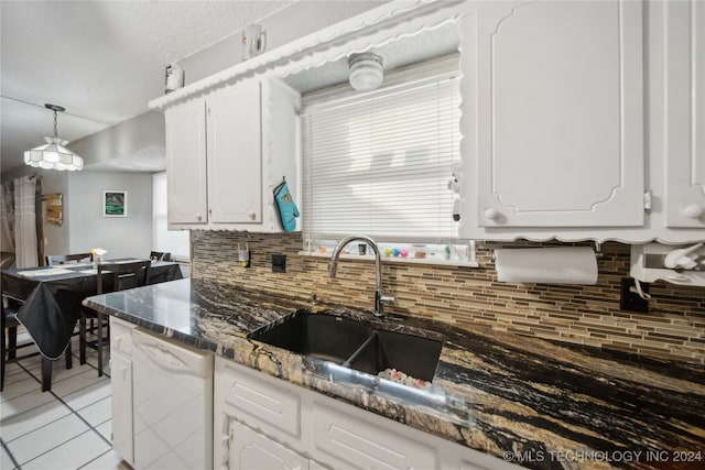 kitchen with tasteful backsplash, white cabinets, sink, dishwasher, and hanging light fixtures