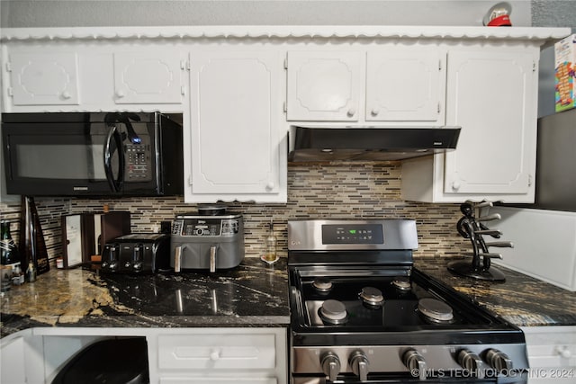 kitchen featuring tasteful backsplash, white cabinets, stainless steel stove, and dark stone counters