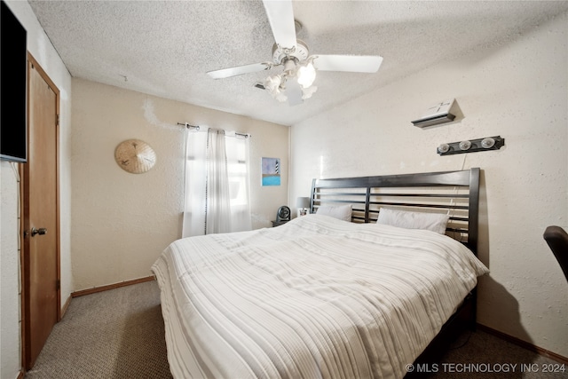 bedroom featuring ceiling fan, carpet floors, and a textured ceiling