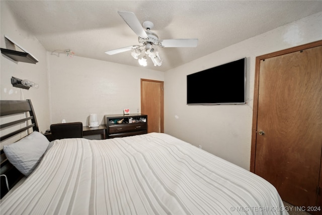 bedroom with ceiling fan and a textured ceiling