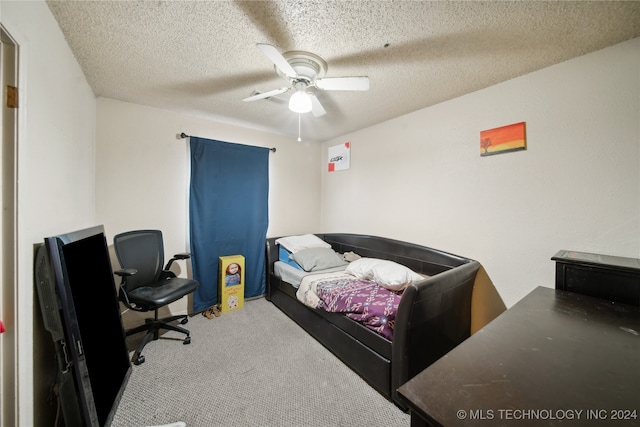 bedroom with ceiling fan, light colored carpet, and a textured ceiling