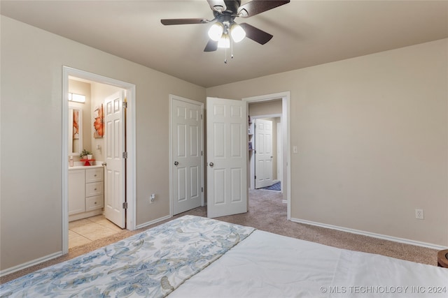 carpeted bedroom featuring ensuite bath and ceiling fan