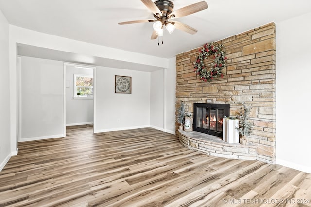 unfurnished living room with ceiling fan, a fireplace, and wood-type flooring