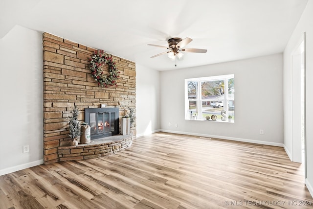 unfurnished living room featuring a fireplace, light hardwood / wood-style floors, and ceiling fan