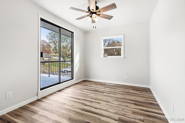 empty room with ceiling fan, light wood-type flooring, and ornamental molding