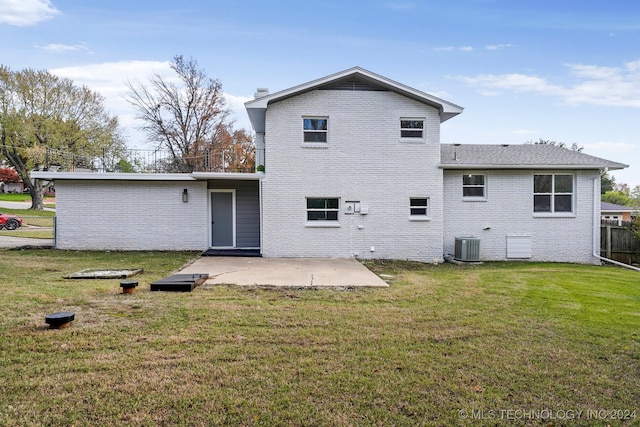 rear view of property featuring a lawn, central AC unit, and a patio