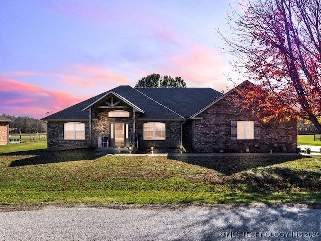 ranch-style home with a yard