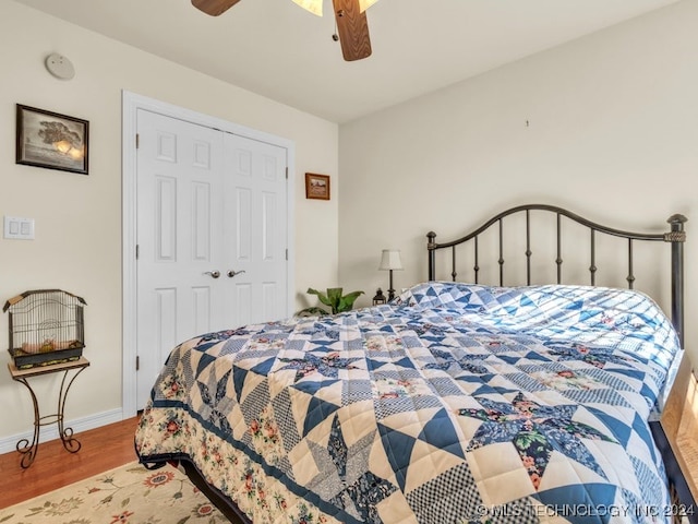 bedroom with hardwood / wood-style floors, a closet, and ceiling fan