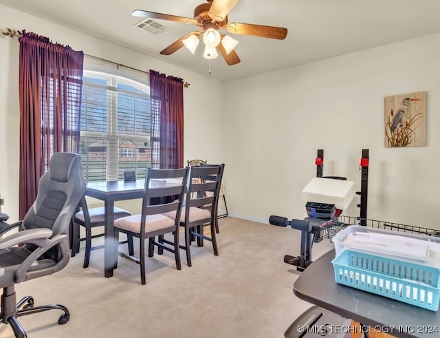 carpeted dining area with ceiling fan