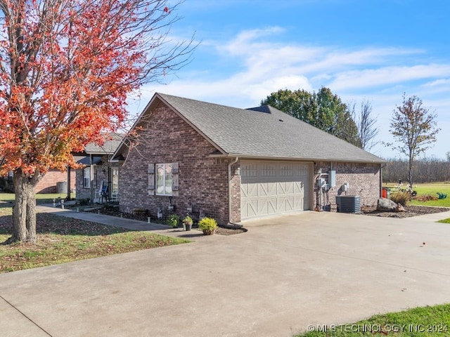 view of side of property featuring a garage and cooling unit