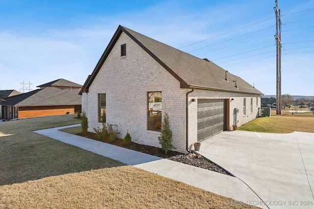 view of property exterior featuring a yard, cooling unit, and a garage