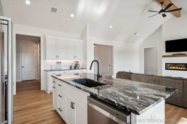 kitchen featuring dishwasher, sink, lofted ceiling, a kitchen island with sink, and white cabinets