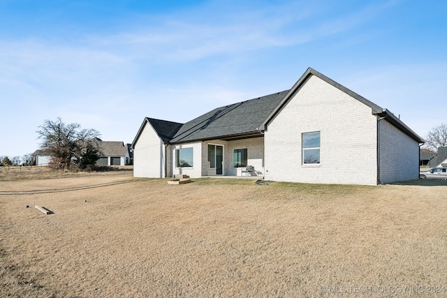 rear view of property featuring a lawn