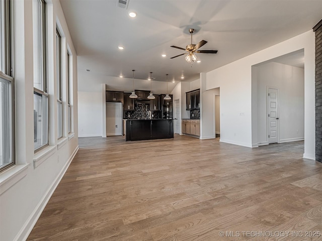 unfurnished living room with light hardwood / wood-style flooring and ceiling fan